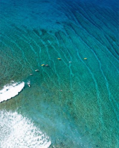 an overhead view of the ocean with people in the water at Bibee Surf in Thulusdhoo