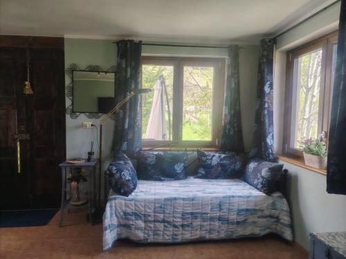 a bedroom with a bed with blue curtains and a window at Casa di Viu' in Viù