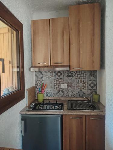 a kitchen with a stove and wooden cabinets at Casa di Viu' in Viù