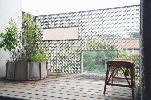 a chair and a potted plant on a wooden deck at Chulin Homestay in Tainan