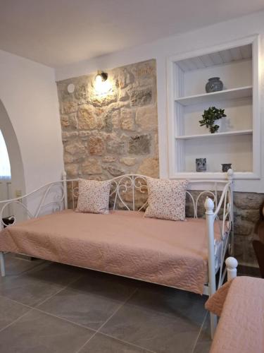 a bed in a room with a stone wall at Patriko Stone House in Fourka