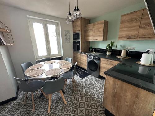 a kitchen with a table and chairs in a room at Bel appartement F4 6 a 7 personnes in Lutterbach
