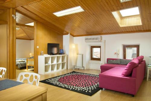 ein Wohnzimmer mit einem rosa Sofa und einem Tisch in der Unterkunft Apartment Bambola in Ajdovščina