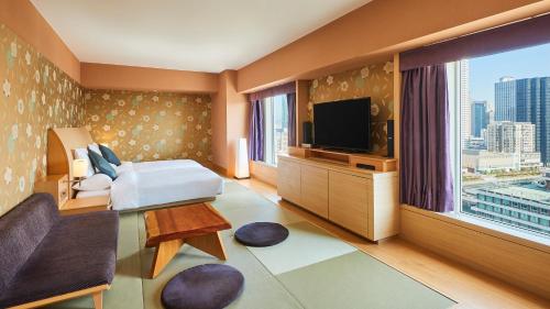 a hotel room with a bed and a flat screen tv at RIHGA Royal Hotel Osaka, Vignette Collection by IHG in Osaka