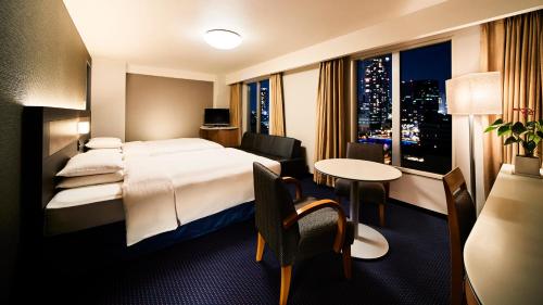 a hotel room with a large bed and a table at RIHGA Royal Hotel Osaka, Vignette Collection by IHG in Osaka