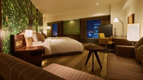 a hotel room with a bed and a desk at RIHGA Royal Hotel Osaka, Vignette Collection by IHG in Osaka