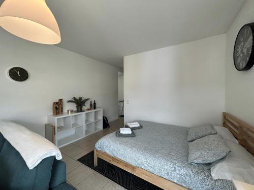 a bedroom with a bed and a clock on the wall at Free Parking - Near the Lake - Lugano apartment in Paradiso