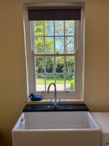 a kitchen sink with a window above it at Hall Cottage, Wighill near York and Leeds in Tadcaster