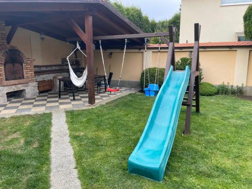 a playground with a slide in a yard at RRR Apartmány 3 in Bojnice