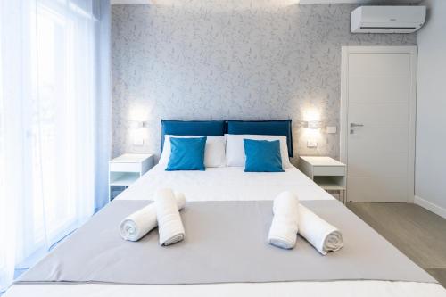 a bedroom with a large white bed with blue pillows at Villa Cola - Vesuvio Garden & Relax in Boscotrecase