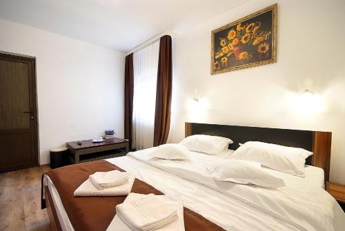 a bedroom with a large bed with white sheets at Casa Bamby in Slănic-Moldova
