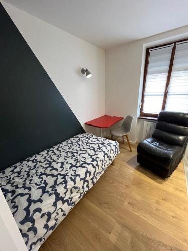 une chambre avec un lit, une chaise et un bureau dans l'établissement Superbe appartement atypique au cœur de Mulhouse, à Mulhouse