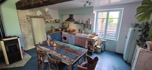 - une cuisine avec une table en bois et un comptoir dans l'établissement La maison colorée, à Deux-rivières