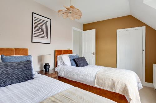 a bedroom with two beds and a ceiling fan at Cosy 3 bedroom house with Free parking and WiFi in Colchester