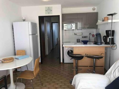 une petite cuisine avec une table et un réfrigérateur dans l'établissement Appt 4 pers dans Marina à 300m de la plage, à Sète