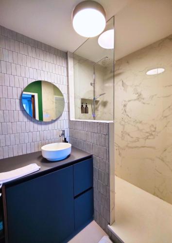une salle de bain avec un lavabo et une douche avec un miroir dans l'établissement La treille Vieux-Lille - 4 pers - Parking, à Lille