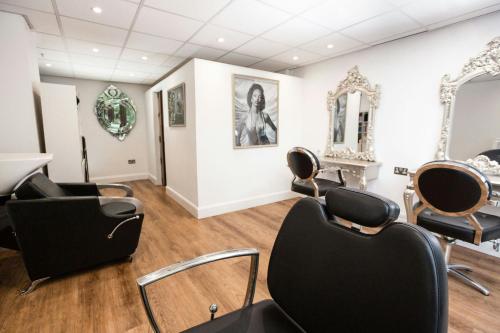 a salon with black chairs and a mirror at London Marriott Hotel Regents Park in London