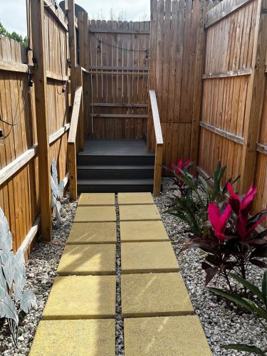 a walkway in a garden with a fence at Tree Top Retreat! Private & close to 5th Ave! in Naples
