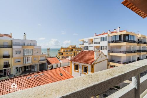a view of buildings and the ocean from a balcony at Casa do Terraço - Center of Santa Cruz with Sea View in Santa Cruz