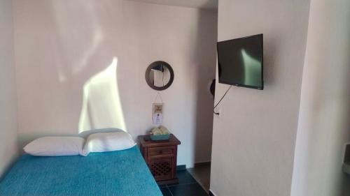 a bedroom with a bed with a tv on the wall at Estudio De La Cinco Puerto Vallarta in Puerto Vallarta