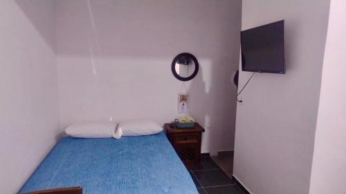 a small room with a bed and a television at Estudio De La Cinco Puerto Vallarta in Puerto Vallarta