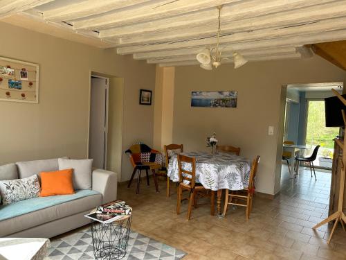 un salon avec un canapé et une table dans l'établissement GÎTE Au Bord De L'Iton, à Crulai