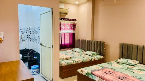 a small room with two beds and a mirror at shree shivnandan homestay in Ujjain