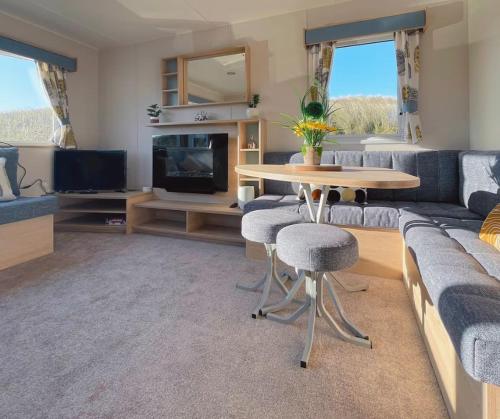 a living room with a couch and a table at Dune Breeze-Haven Perran Sands Holiday Park in Perranporth