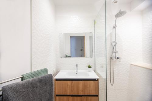 une salle de bain avec un lavabo et une douche avec un miroir dans l'établissement Magnifique appartement, central, à La Ciotat