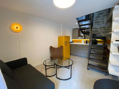 a living room with a couch and chairs and a staircase at La Nine in Aigne