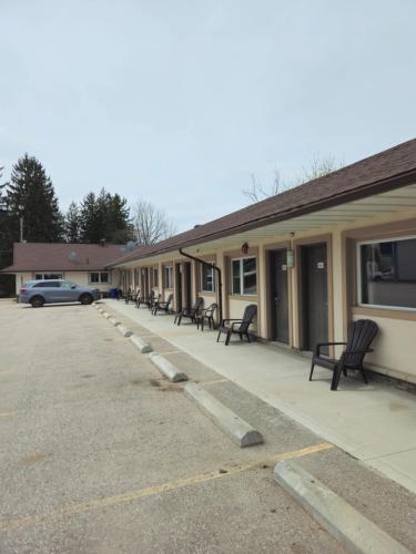 a row of benches in front of a building at Forest Plaza Motel in Mount Forest