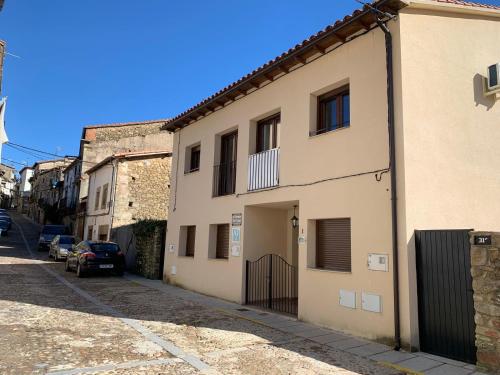 a building with a gate on the side of a street at El Hondón del Lugar in Hoyos