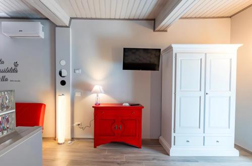 a room with a red cabinet and a tv on the wall at Antico Borgo Monregale in Mondovì