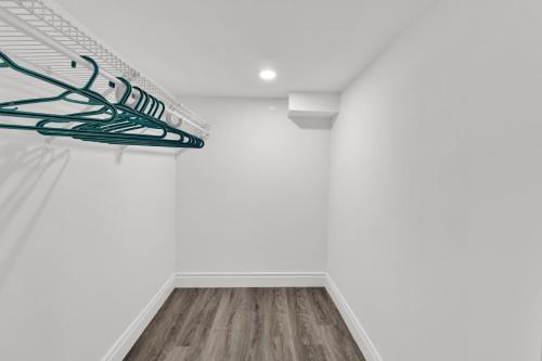 a staircase in a white room with a wooden floor at Cozy Ancaster Hamilton Apartment in Hamilton
