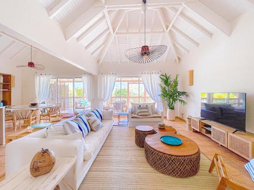 un soggiorno con un divano bianco e una TV di Sable Bleu Elegant 2-Bedroom Oceanfront Apartment a Orient Bay