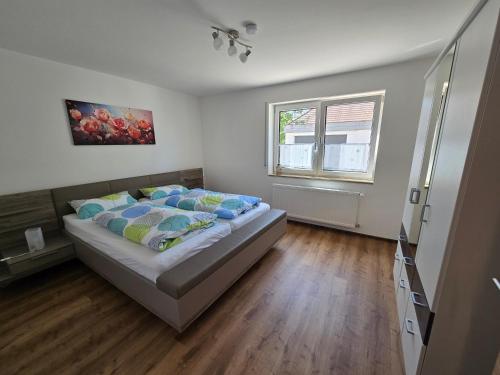 a bedroom with a bed with blue pillows and a window at Ferienwohnung Kurzendorfer in Lauterhofen