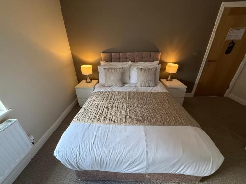 a bedroom with a large bed with two lamps at SPIRE VIEW at THE SPREAD EAGLE in Chesterfield