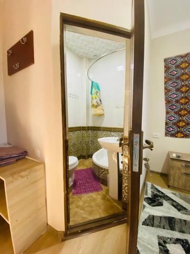 a bathroom with a toilet and a sink and a mirror at Mashhur in Bukhara