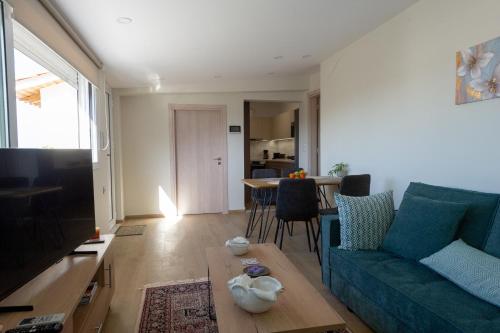 a living room with a blue couch and a table at Etherial Comfy House 1 in Kalamata