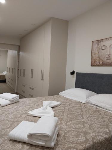 a bedroom with two beds with towels on the bed at Etherial Comfy House 1 in Kalamata
