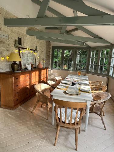 une salle à manger avec une table et des chaises blanches dans l'établissement La Buissonnière, à Dannemarie