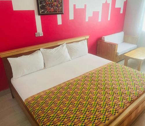 a large bed in a room with a red wall at Theo Good Life Hotel in Big Ada