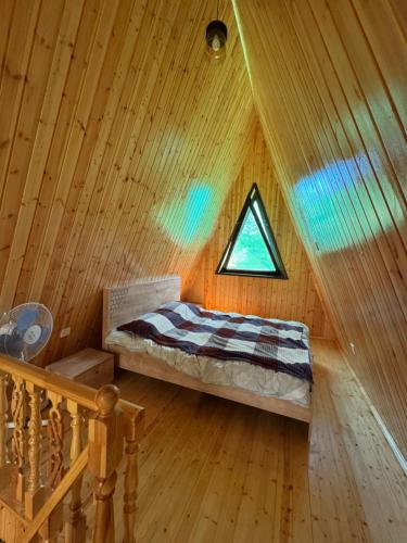 a bedroom with a bed in a wooden cabin at Lerik kirayə ev in Lerik