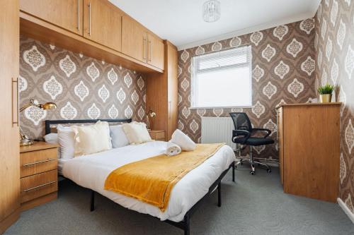 a bedroom with a bed and a desk and chair at Boutique 3bd Opposite Etihad & Coop - Free Parking - Pool Table in Manchester