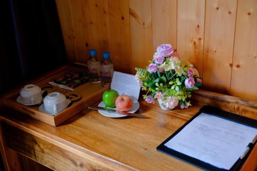 a wooden table with a tablet computer and flowers on it at Bungalow Ven Sông in Ấp Phú Hòa (2)