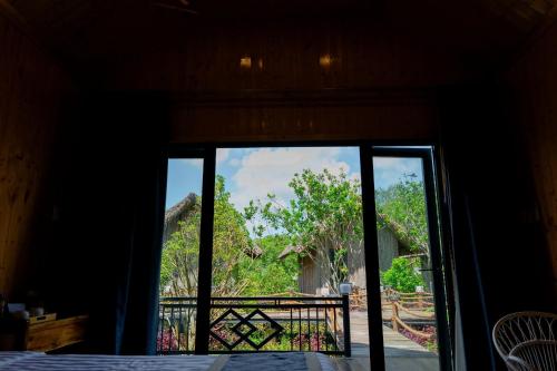 a sliding glass door with a view of a yard at Bungalow Ven Sông in Ấp Phú Hòa (2)