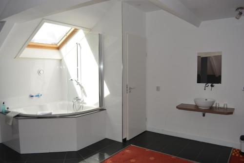 a bathroom with a bath tub and a window at Hotel Oranjeoord in Apeldoorn