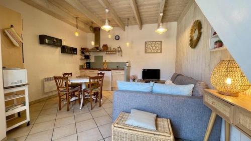 un salon avec un canapé bleu et une table dans l'établissement Ty LOCH - port et plage à pieds, à Camaret-sur-Mer