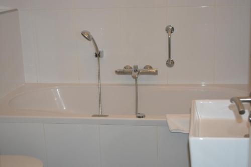 a white bath tub sitting next to a white toilet at Hotel Oranjeoord in Apeldoorn