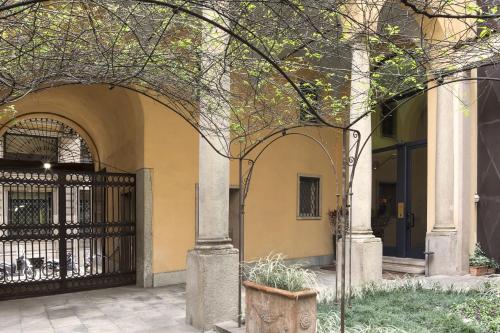 numa l Camperio Rooms & Apartments في ميلانو: مدخل لمبنى مع بوابة سوداء
